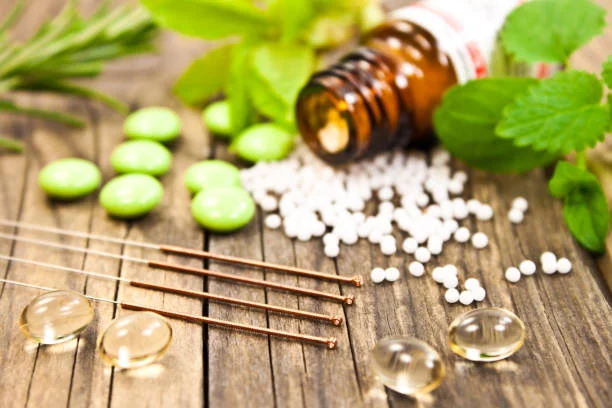 Natural remedy pellets in a bottle beside fresh green leaves