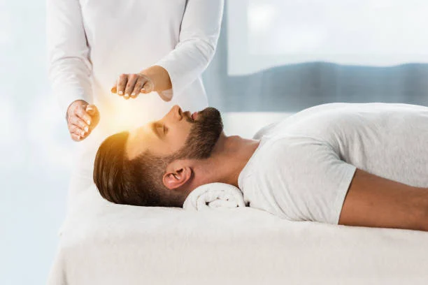 A practitioner's hands held above a client's head during a Reiki session
