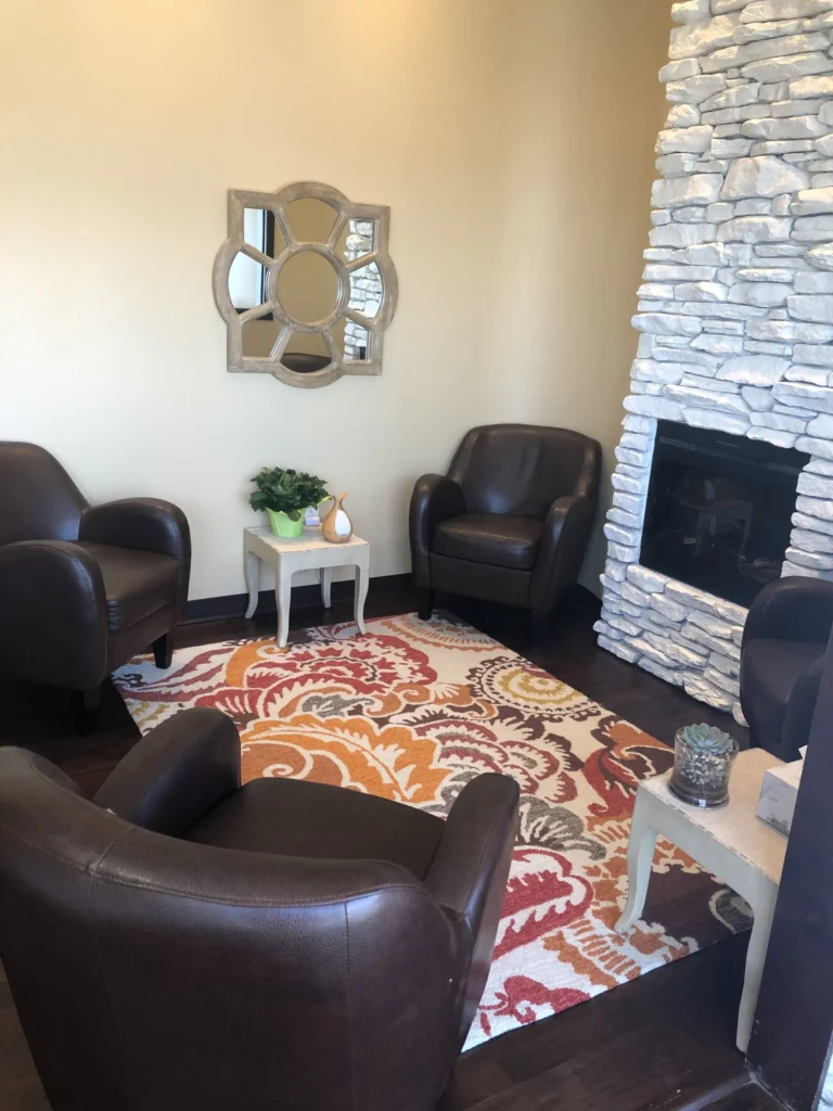 Seating and stone fireplace in the reception lounge at Peace of Mind Massage Therapy Centre